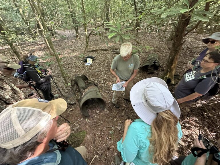 A group of people look at an old still at Stone Mountain State Park.